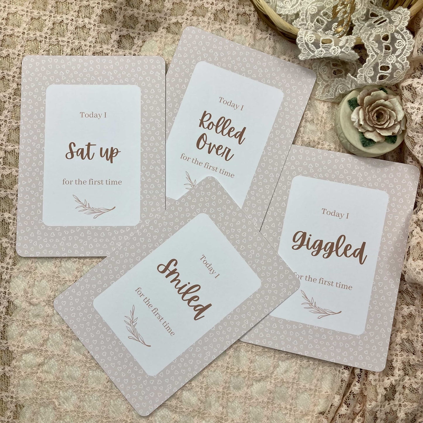 Set of milestone cards with baby milestone phrases on a textured surface