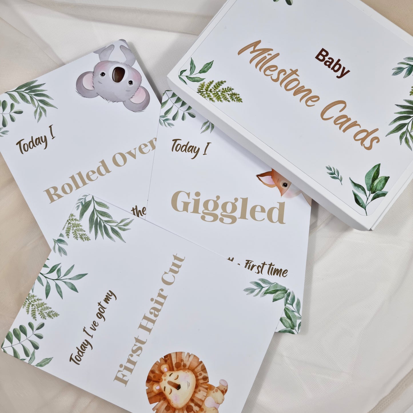 Baby milestone cards with animal illustrations and text on a light background