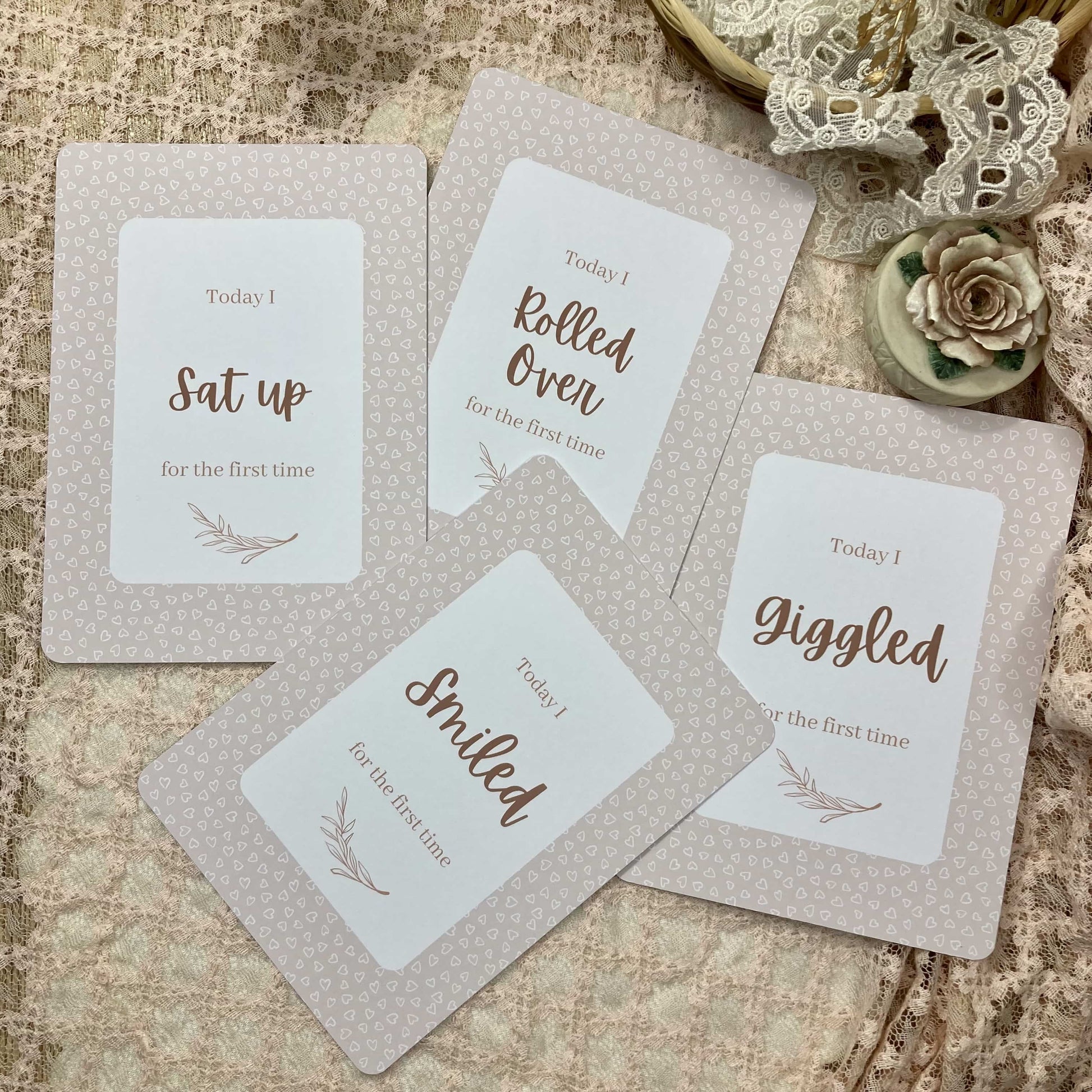 Set of milestone cards with baby milestone phrases on a textured surface