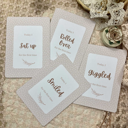 Set of milestone cards with baby milestone phrases on a textured surface